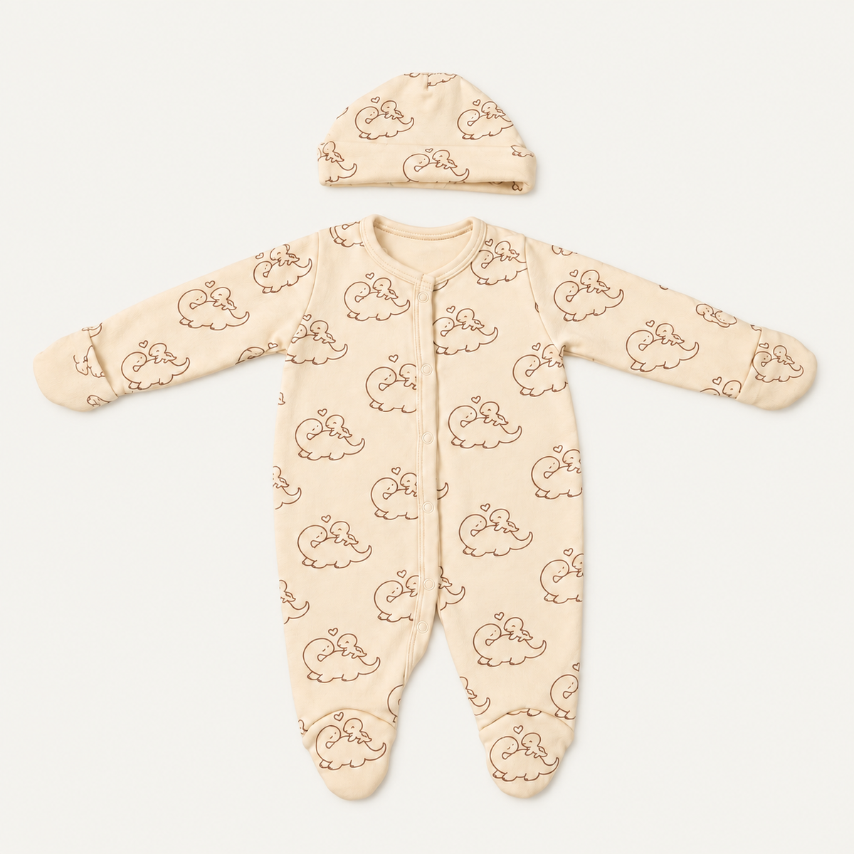 The Dino Footed Onesie with its matching hat, dinosaur-and-heart print in cream
