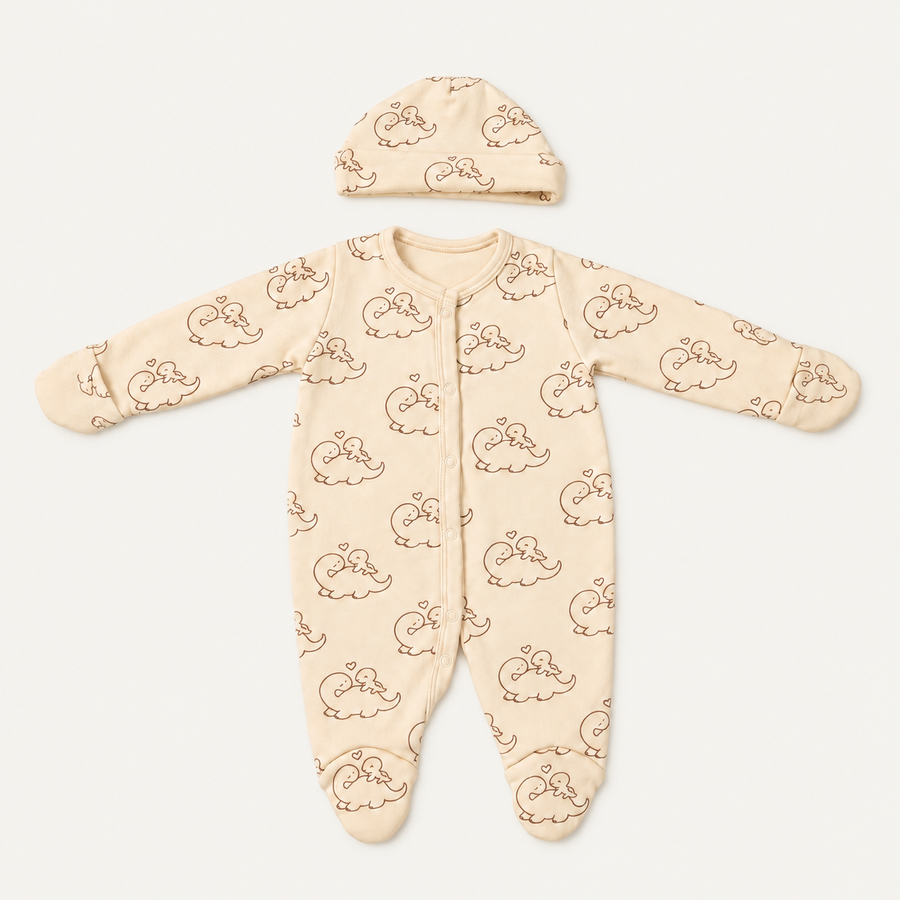The Dino Footed Onesie with its matching hat, dinosaur-and-heart print in cream